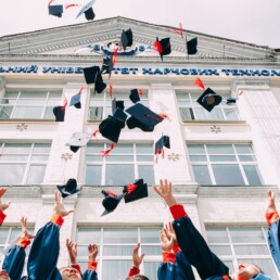University students throwing graduation caps into the sky in celebration